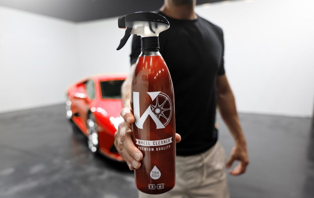 Imagen del nuevo limpiador de llantas de Kriime delante de un Ferrari